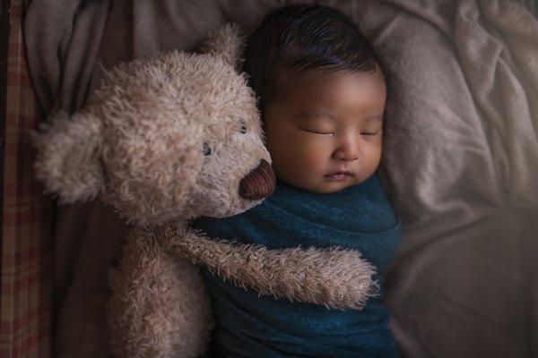 Newborn Baby Snuggling with Teddy Bear