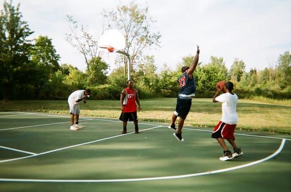 Classic team members playing basketball as a team building event.