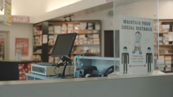 Cash register and social distancing sign at Alan's Shoes Speedway