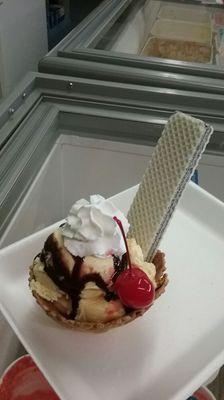 1 scoop of ice cream topped with chocolate whipped cream and a cherry with a vanilla wafer