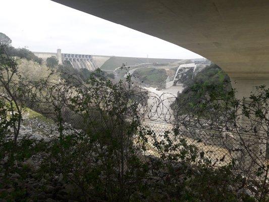 view of dam and auxiliary dam from underneath Folsom Lake Crossing during rain