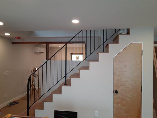 Custom built handrail with 2"× 3/8" flat bar top, and 1/2" round stock pickets, painted satin black.