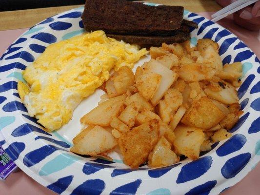 Breakfast platter with scrambled eggs, home fries, scrapple and toast.