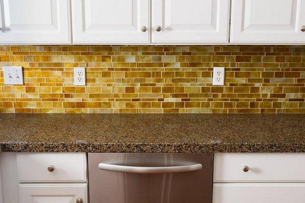 Metropolis Honey mosaic tile backsplash with Terra Ombra granite countertops.