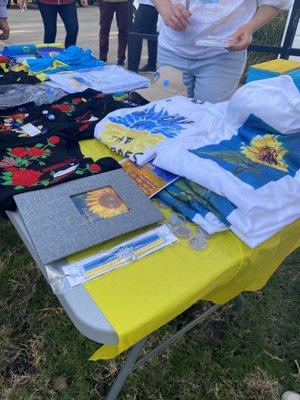 Merchandise table. We bought two of the sunflower tees to help supper the efforts in Ukraine