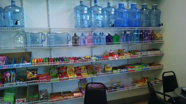 The wall of candies for sale with more water bottles for sale.