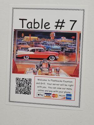 This type of sign is posted at each table with a different number. It lets you know how you can view the menu and how you can pay online.