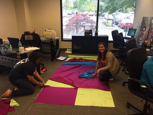 Behind the Scenes Volunteer Nathalia knows the cuts on these soon to be "Super Hero Capes" are essential in helping children in hospice care