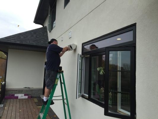 Tom T installing outdoor speakers.