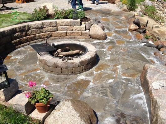 Flagstones create a unique patio around this manufactured stone fire pit.