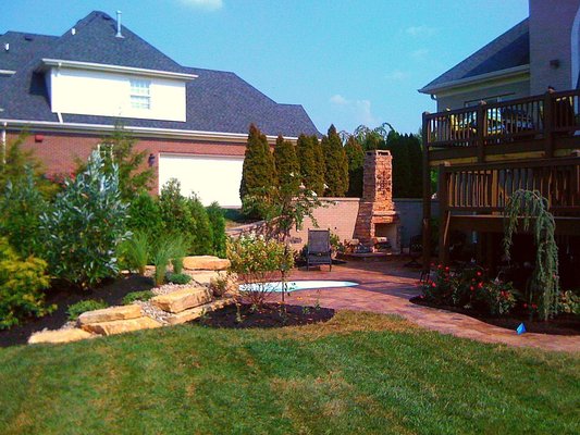 Patio with outdoor fireplace, In ground spa, lush landscaping.