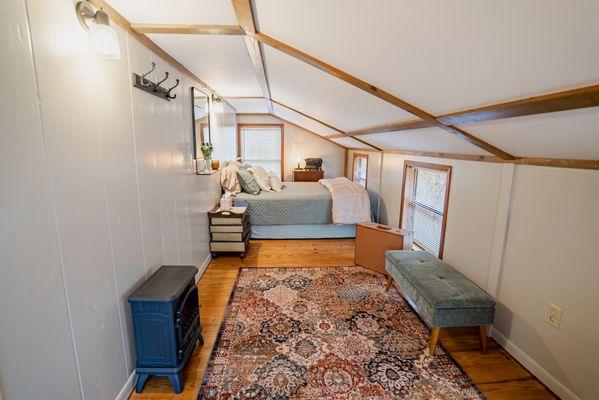 The loft bedroom extends the full length of the Treehouse cabin. A queen sized bed and sitting area make this a great space to rest.