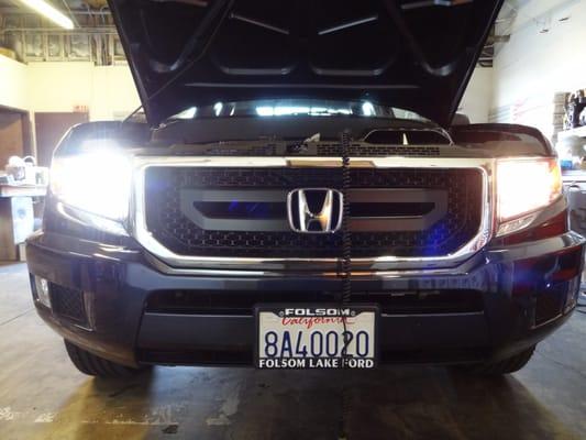 Left headlight is showing a comparison of a led head light bulb in action in comparison to the driverside factory halogen lamp.