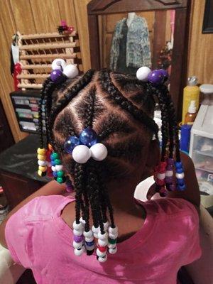 three braided ponytails, one on top, one in the back