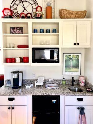 Kitchenette with glassware, dinnerware, and cutlery.