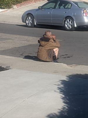 One of your residents sitting in my driveway going through a fistful of cigarette butts. Leaving them all behind when he's done