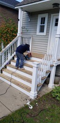 Removing old coat by sanding boards.