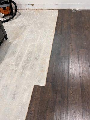 Shows laminate floor directly on top of concrete - no underlay between the surfaces.