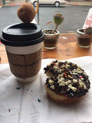 Latte with a munchkin and a delicious donut