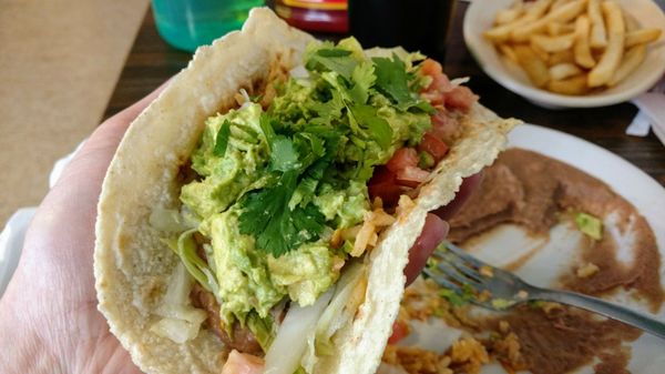 Corn tortillas with a side of rice, beans, guacamole, lettuce and tomatoes.  Perfection!!