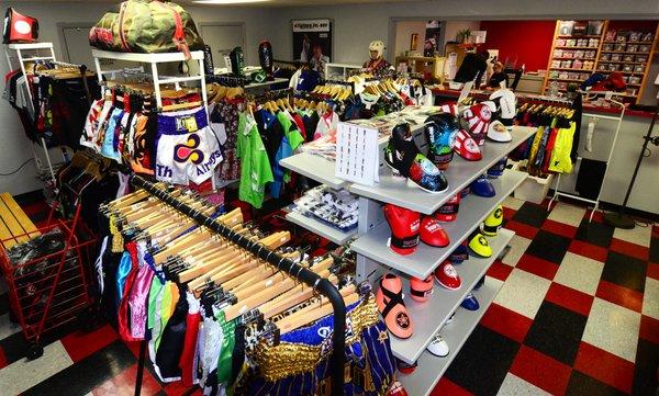 Display of martial arts supplies including foot protectors and gloves for point fighting karate and Muay Thai shorts.