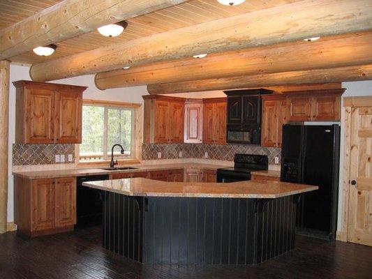 Logs in ceiling create dramatic look to this kitchen.

 ?After living in a traditional log home and dealing with cracking, le...