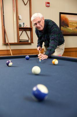 A resident plays billiards in Shaker Pointe's lounge.