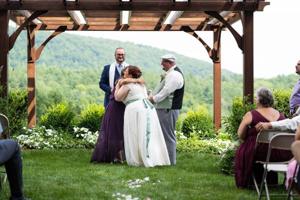 bride hugging sister during ceremony at Warfield House Inn in Charlemont, MA