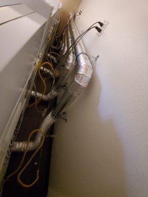 Replaced old inefficient soft flex hoses with rigid metal ducts in an apartment building laundry room.