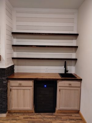 Wet bar of fireplace build out. Blackstone sink and faucet. Wine fridge under the counter. Counter tops made from 100 year old reclaimed