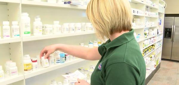 Sam retrieving medication from the shelf.