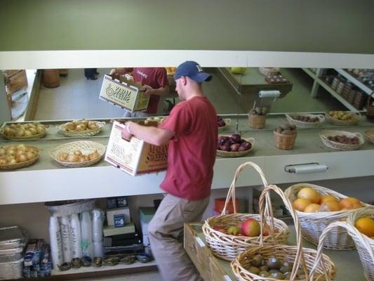 Store owner, Aaron, stocking onions and potatoes.