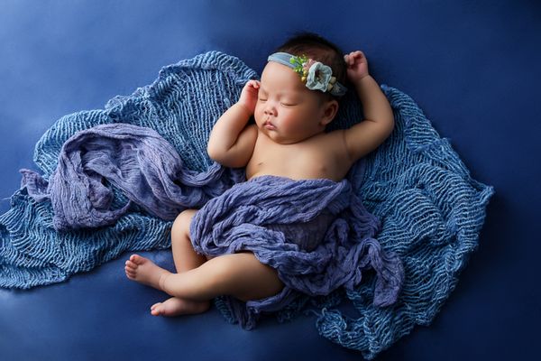 Newborn photographer Portsmouth New Hampshire infant baby girl surrounded in purple sleeping with flower headband