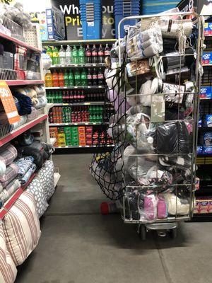 Houseware items left, bin with blankets on right-partially blocking aisle.