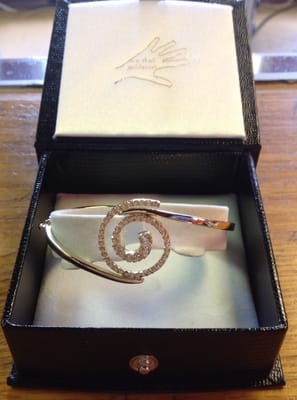 special order, custom 14kt yellow gold bangle with 18kt. yellow gold diamond swirl center