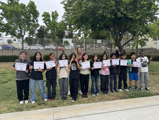 Students in the 5th grade getting an award with the school principal in the back!.