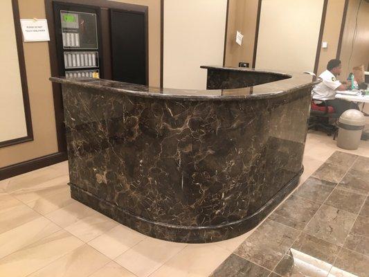 Breccia Emperador reception desk with curved panels