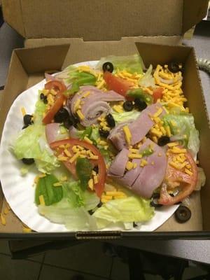 A salad on a plate out inside a box.... Weird.