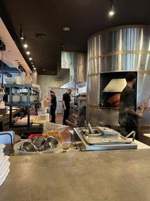 Inside the restaurant in front of the brick oven