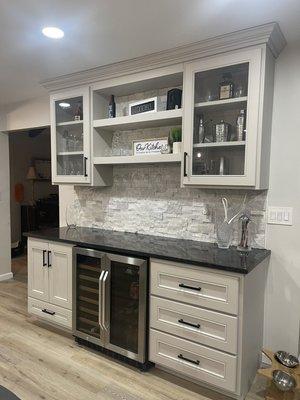 Bar with custom cabinets, Rock background with dual fridge. Black countertops make this bar pop.