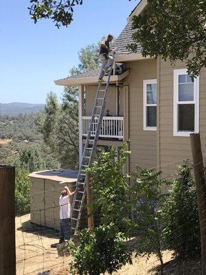 Gutter cleaning prior to installation of covers, two stories up.