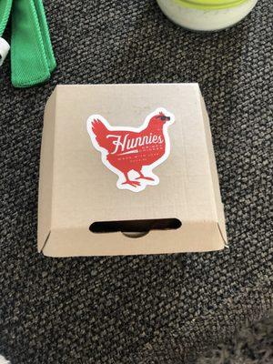 Take out box holding a buffalo chicken sandwich