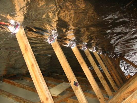 Reflective barriers placed underneath the roof deck reduces heat transfer from outside of the house into the attic space