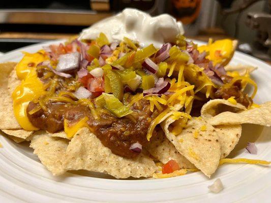 Loaded nachos with cheese, chili, onion, diced tomatoes, jalapeños and sour cream.