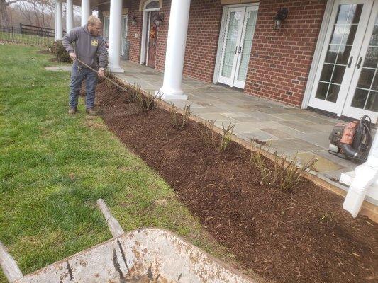 Clean out and remulch a flower bed with brother in law