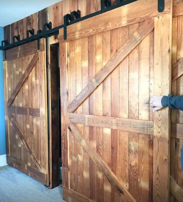 Full wall closet with sliding barn wood doors added to a farmhouse master bedroom.