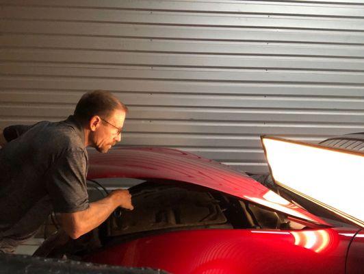 The Hail Expert working on a new cherry red Mazda Miata