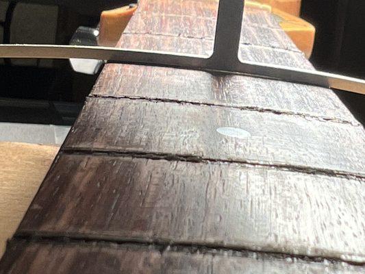 Checking fretboard radius after correcting, prior to installing new frets.