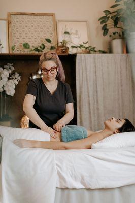 A woman receives Manual Lymphatic Drainage to her abdomen for post-op swelling.