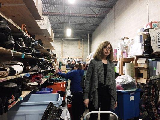 Hope, the founder in the warehouse by the shoe sorting section. They always need shoes!